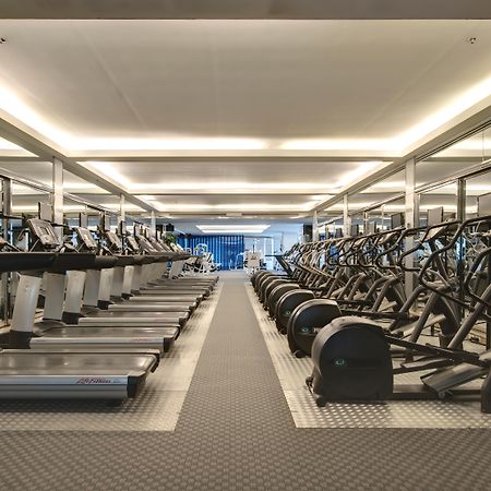 帕色哇公主酒店【SHA Extra Plus】 曼谷 外观 照片 The photo shows a modern gym space featuring rows of exercise equipment. On one side, there are several treadmills and possibly elliptical machines lined up. The other side has stationary bikes and strength training equipment, arranged neatly. The gy